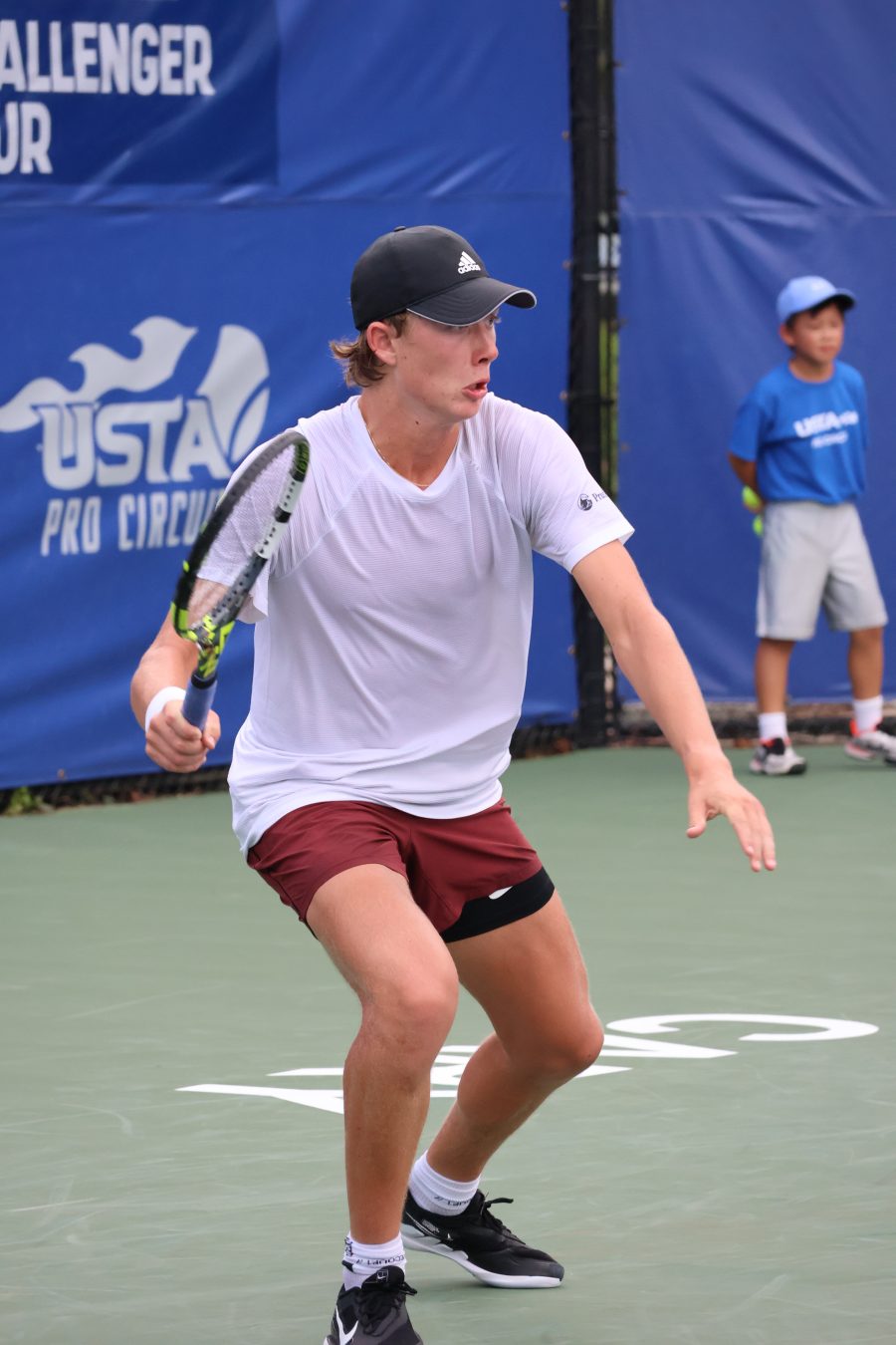 Ethan Quinn colpisce un diritto durante una partita di tennis