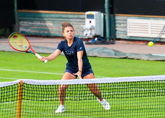 Jasmine Paolini in posizione di risposta su un campo in erba