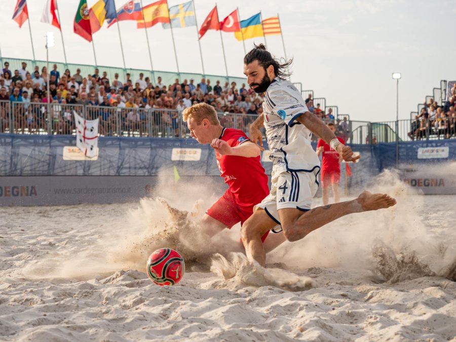 Giocatore di beach soccer durante una conclusione sulla sabbia