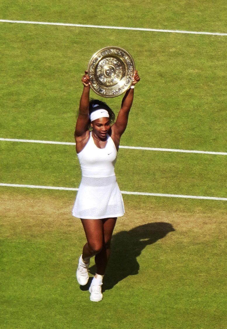 Serena Williams sul campo centrale di Wimbledon con il trofeo