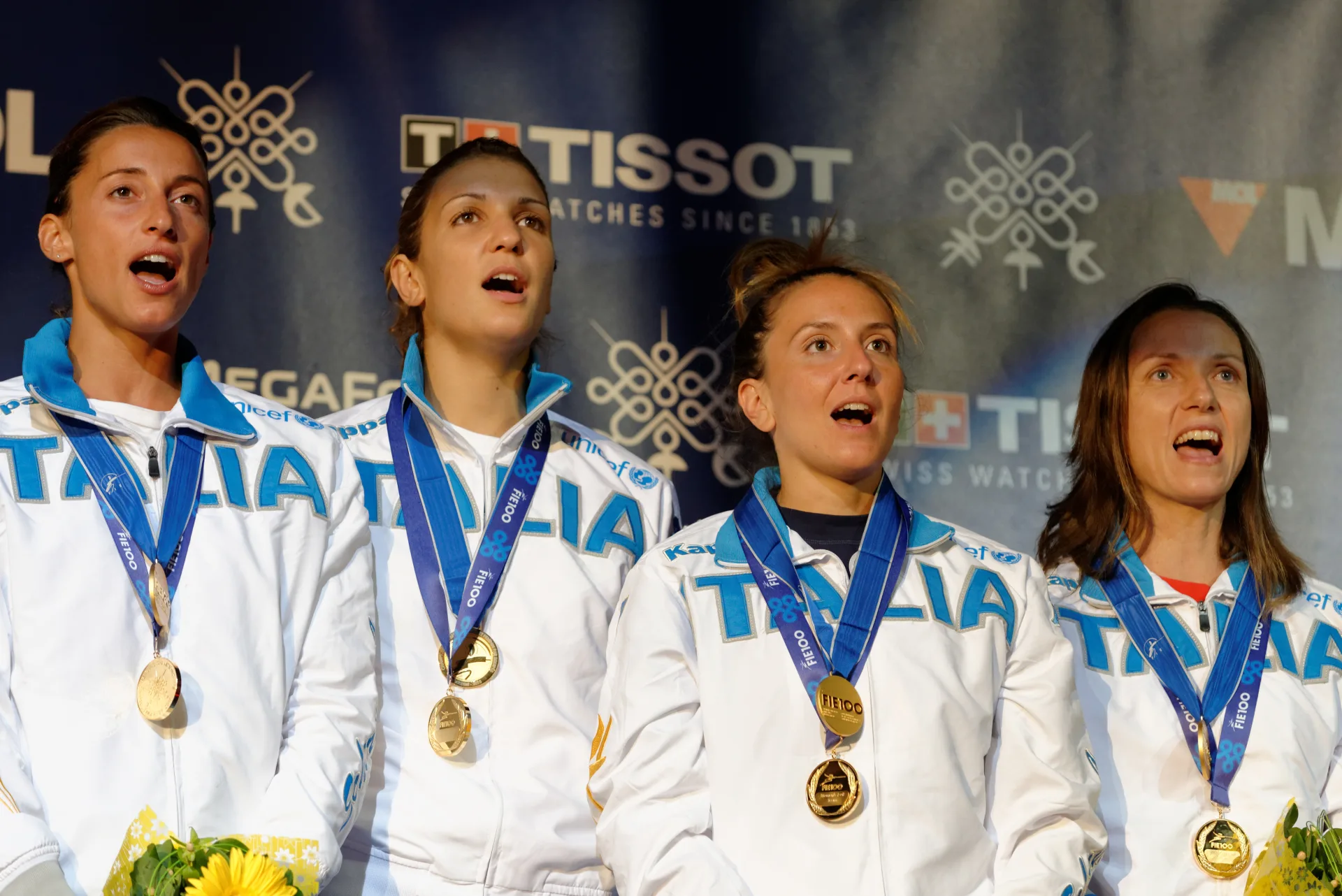 Squadra italiana di scherma sul podio con medaglie