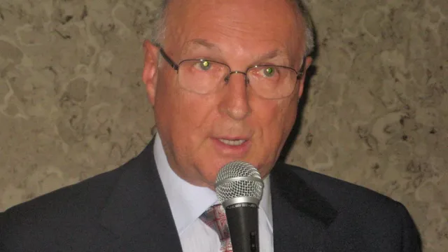 Livio Berruti con microfono durante una commemorazione olimpica a Torino