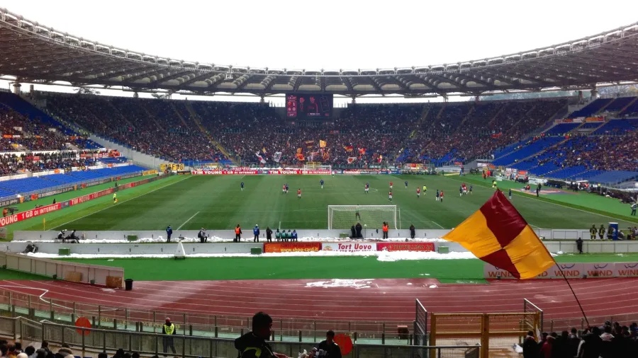 Stadio Olimpico con tifosi della Roma e bandiera giallorossa
